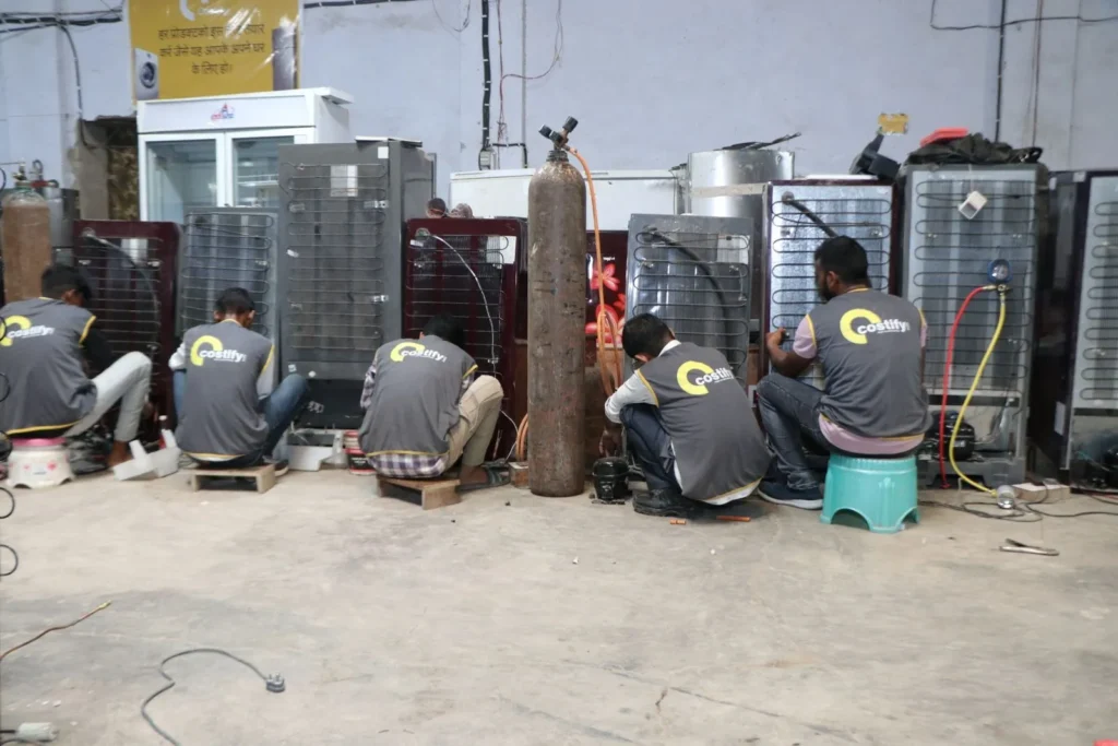 Costify team refurbishing refrigerators, washing machines, and ACs using AI-powered diagnostics in Delhi warehouse
